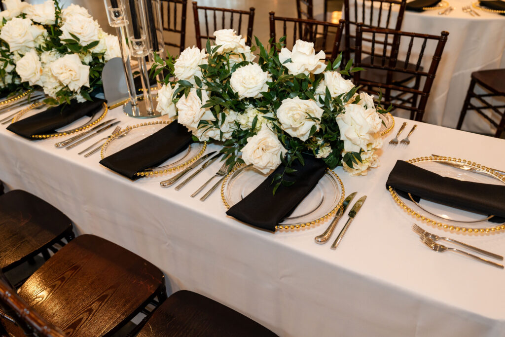 A chic black-and-white invitation suite with champagne accents set the tone for their timeless, minimalist wedding aesthetic." and "Sleek linens, bold florals, and champagne details brought sophistication to the reception tablescapes.